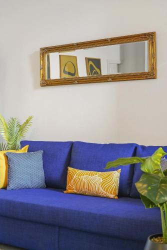 a blue couch with pillows and a mirror at Stone Pit Apartments in Golborne