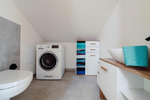 a bathroom with a washing machine and a sink at Dom pod Lipami in Bachórz