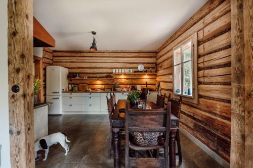 a kitchen with wooden walls and a dining room with a table at Dom pod Lipami in Bachórz