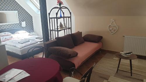 a living room with a couch and a bed at Gréta Apartman in Hajdúszoboszló