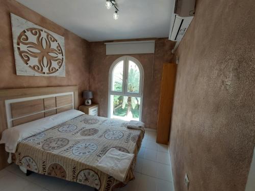 sypialnia z łóżkiem i oknem w obiekcie Bungalow Alkabir Playa w mieście El Campello