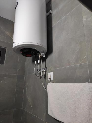 Luz blanca en el baño con toalla en Klea Rooms, en Velipojë