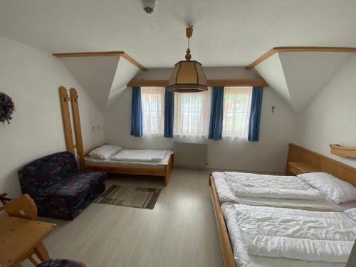 a room with two beds and a chair in it at Waldschlössl Gasthof in Sankt Lorenzen ob Murau