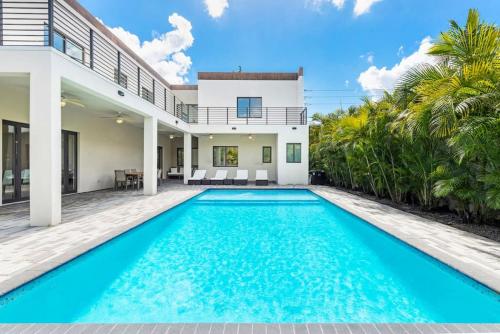 a swimming pool in front of a house with a villa at Granada Modern Luxury in Massive Mansion with Heated Pool in Miami