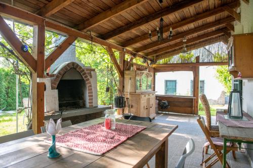 an outdoor kitchen with a table and a fireplace at Hermann Cottage in Keszthely