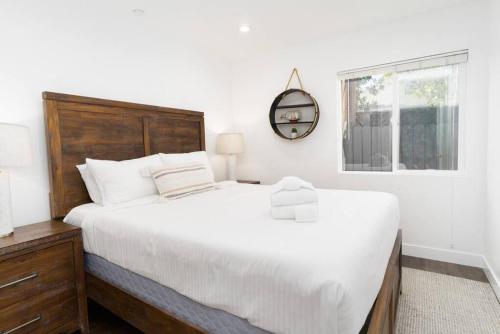 Un dormitorio con una gran cama blanca y una ventana en North Park Retreat! Trendy & Tranquil 2br/2ba Home, en San Diego