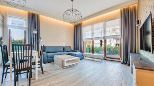 a living room with a blue couch and a table at Gdynia Nowe Orłowo, Sun & Snow in Gdynia
