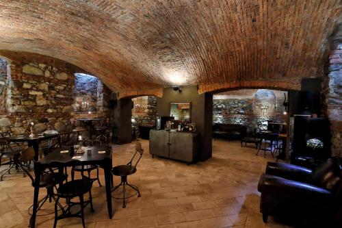 a room with tables and chairs and a stone wall at Villa Lucini 1886 "La Dolcevita" Cottage 2, close to Lake Como and Milan in Calco