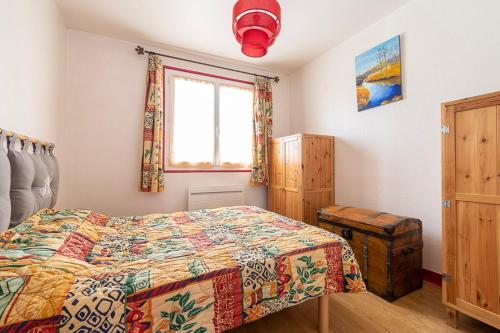 une chambre avec un lit avec une couette colorée et une fenêtre dans l'établissement Appartement, 6 personnes centre Villard-de-Lans, à Villard-de-Lans