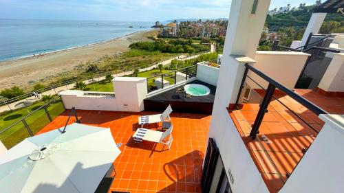 un balcón de una casa con vistas a la playa en Exclusive luxury frontline beach penthouse Casares del mar - Estepona, en Casares