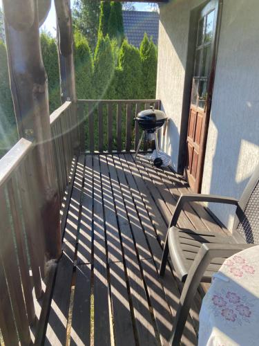a patio with a grill and a chair on a porch at Gunia Gesthouse in Łukta