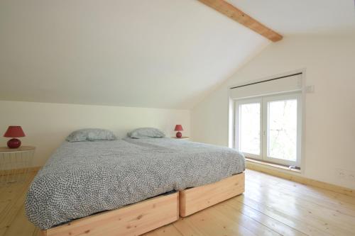 une chambre blanche avec un lit et une fenêtre dans l'établissement Adorable maison d'hôtes avec piscine- tiny house, à Saubrigues
