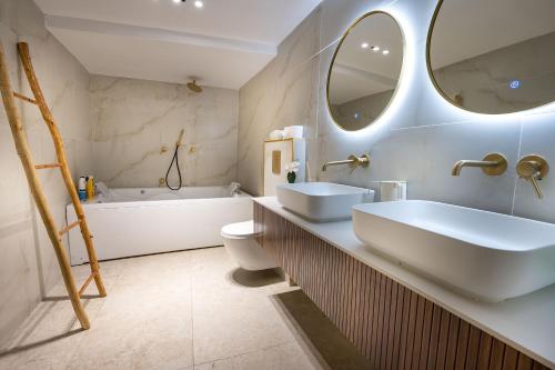 a bathroom with two sinks and a tub and a toilet at Moses Luxury Vacation Homes-מתחם פיניקס in Safed