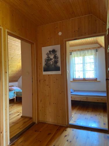 an empty room with a bedroom and a window at Gunia Gesthouse in Łukta