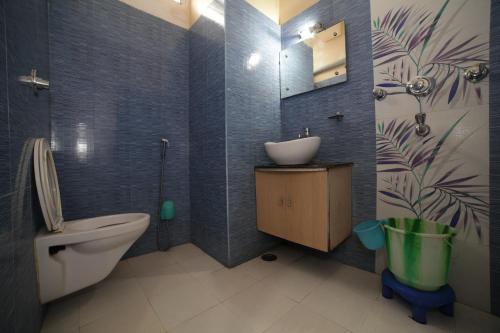 a bathroom with a toilet and a sink in it at Hotel Satkar in Katihār