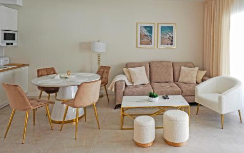 uma sala de estar com um sofá, uma mesa e cadeiras em Apartament Sea Star em Pogorzelica