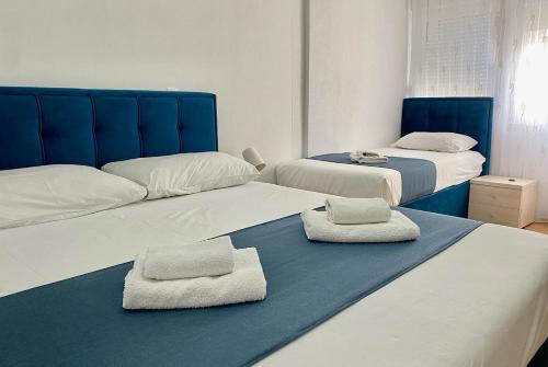 two beds with towels on them in a bedroom at Apartments Domane Nenad in Neum