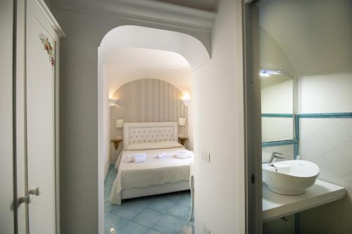 Habitación con baño con cama y lavabo. en Le Suites della Principessa en Ravello