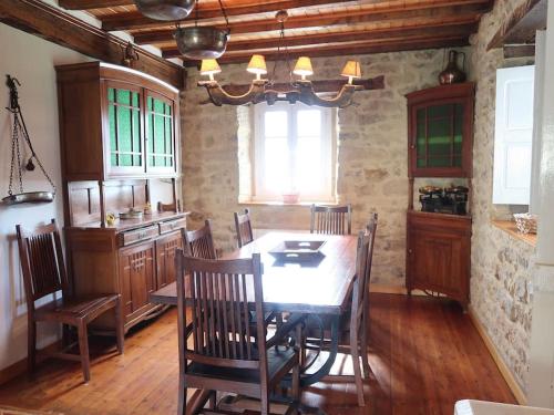 a dining room with a table and a kitchen at LA CASONA DE DON ELÍAS in Silió