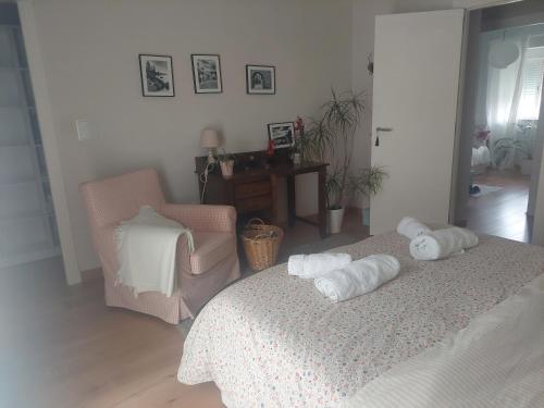 1 dormitorio con 2 toallas en una cama y una silla en Casa rural el atardecer, en Belchite