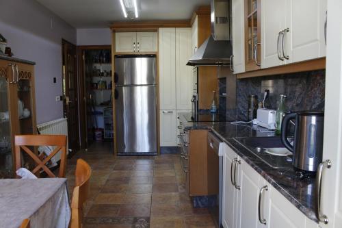 una cucina con frigorifero in acciaio inossidabile di O BARCO DE VALDEORRAS LUZ Y ALEGRÍA a O Barco de Valdeorras