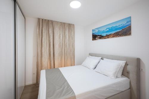 a bedroom with a white bed and a window at Salt&Soul Residence in Povljana
