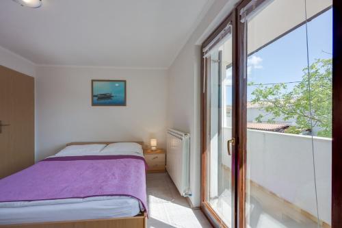 Un dormitorio con una cama y una ventana grande. en Holiday House Planik, en Brest