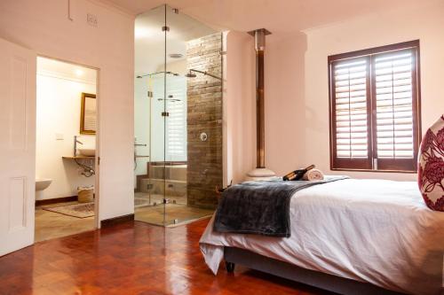 a bedroom with a bed and a glass shower at Ayama Manor House in Wellington