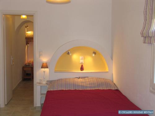 a bedroom with a red bed with a yellow headboard at Afroditi studios in Kampos Paros