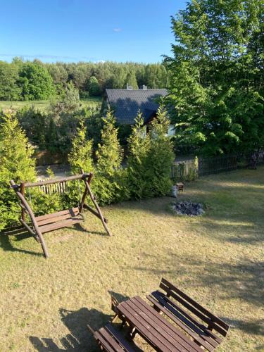 a group of benches sitting in a yard at Gunia Gesthouse in Łukta
