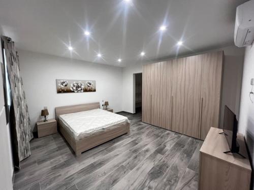 a bedroom with a bed and a wooden cabinet at Zejtun 3-Bedroom Modern Apartment in Żejtun