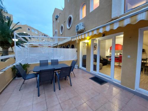 a patio with a table and chairs on a balcony at Bungalow Alkabir Playa in El Campello