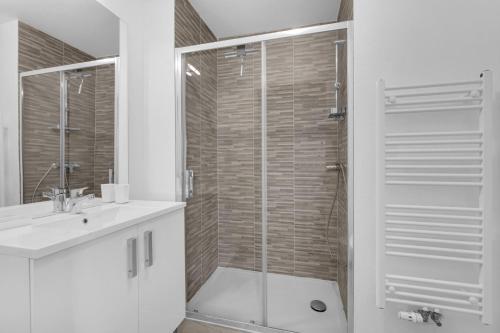uma casa de banho com um chuveiro e uma porta de vidro em La Marquette - Appartement avec balcon em Toulouse