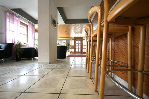 a lobby with a row of wooden stools at Landhotel Hirsch in Sankt Johann