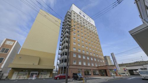 a tall building on a city street with at Toyoko Inn Oita Nakatsu Ekimae in Nakatsu