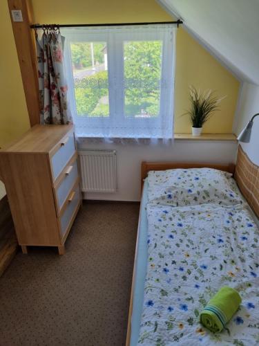 a bedroom with a bed and a dresser and a window at Penzion U našich in Mladé Buky