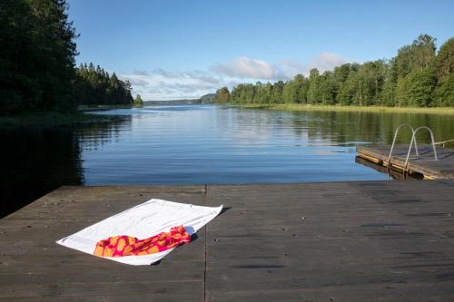 um saco de papel sentado numa doca ao lado de um lago em Sikfors Herrgård em Hällefors