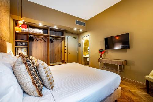 a bedroom with a large bed and a flat screen tv at Hotel Duomo Firenze in Florence