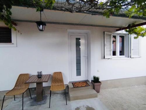 a table and chairs in front of a white house at Apartment Aurora in Hvar