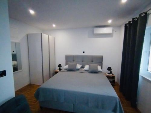 a bedroom with a large bed with a blue blanket at Apartment Aurora in Hvar