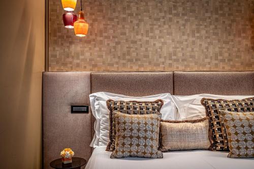 a bedroom with a bed with pillows and a headboard at Hotel Duomo Firenze in Florence