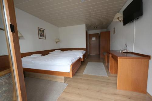 a room with two beds and a television in it at Landhotel Hirsch in Sankt Johann