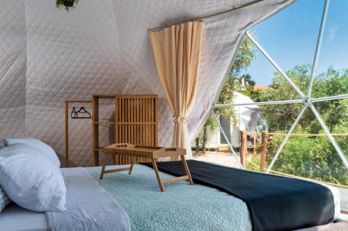 a bedroom with a bed and a window at luxury dome tents ikaria ap'esso in Raches