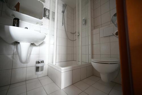 uma casa de banho com um lavatório e um WC em Landhotel Hirsch em Sankt Johann