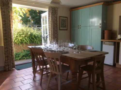 ein Esszimmer mit einem Tisch und Weingläsern darauf in der Unterkunft Secluded cosy cottage in Newbury