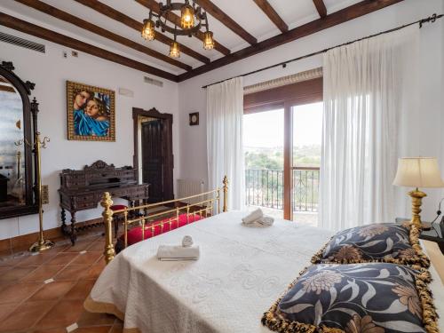 een slaapkamer met een bed en een groot raam bij Tu Villa Rural Los Campesinos 4 Dormitorios in Alhaurín el Grande
