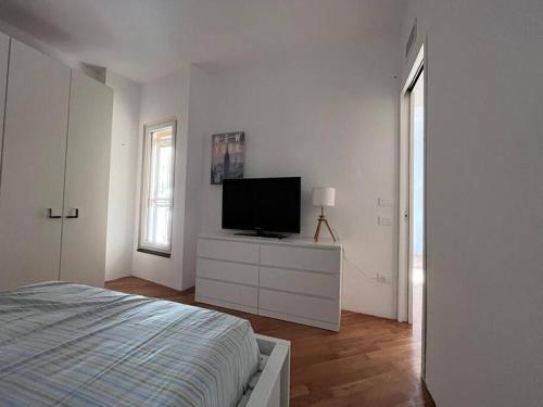 1 dormitorio blanco con 1 cama y TV de pantalla plana en Da Mauro Apartment, nel cuore di Marigliano en Marigliano