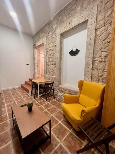 sala de estar con sofá amarillo y mesa en Apartamento Villanubla, en Villanubla