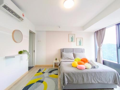 ein Schlafzimmer mit einem Bett mit bunten Kissen darauf in der Unterkunft Empire City PJ Studio Suites by Manhattan Group in Petaling Jaya