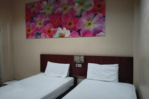 - 2 lits dans une chambre ornée d'une peinture murale dans l'établissement SPOT ON 92648 Wisma Padi Syariah Panyipatan, 